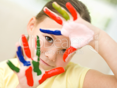 Portrait of a cute girl playing with paints