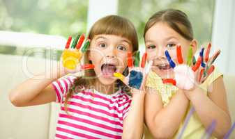 Little girls are painting with gouache