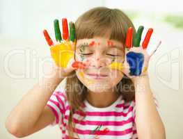 Portrait of a cute girl playing with paints