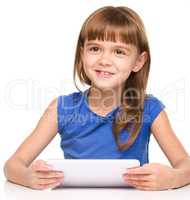 Young cheerful girl is using tablet