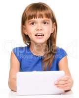 Young cheerful girl is using tablet