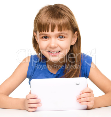 Young cheerful girl is using tablet