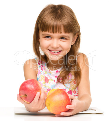 Little girl with red apples