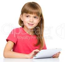 Young cheerful girl is using tablet