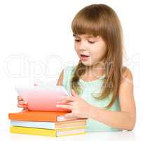 Young cheerful girl is using tablet