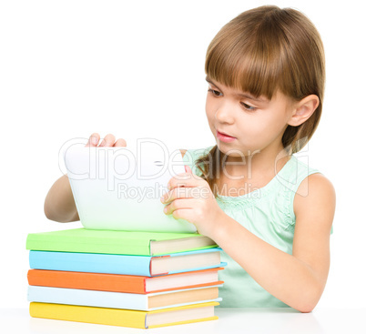 Young girl is using tablet while studying