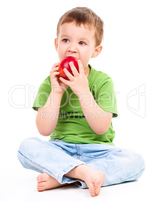 Portrait of a cute little boy with red apple