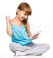 Young girl is playing game using tablet