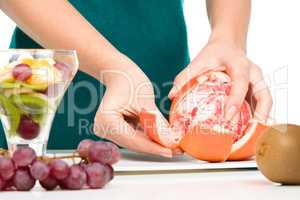 Cook is peeling grapefruit for fruit dessert