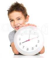 Boy is holding big clock