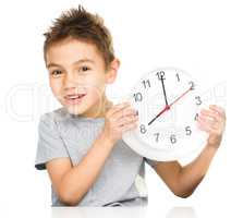 Boy is holding big clock