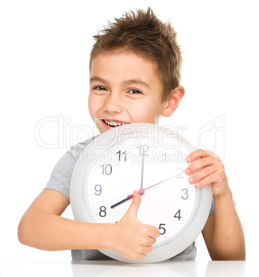 Boy is holding big clock