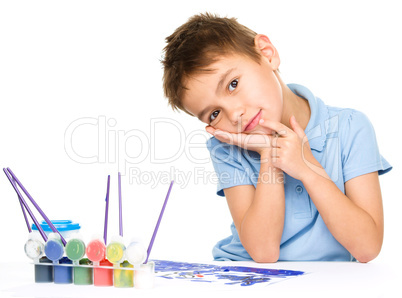 Young is daydreaming while drawing with paints