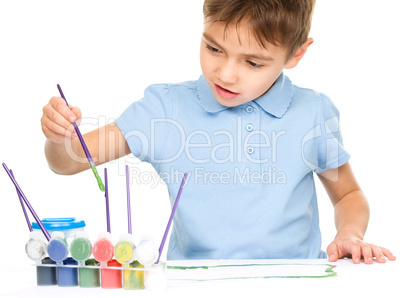 Boy is playing with paints