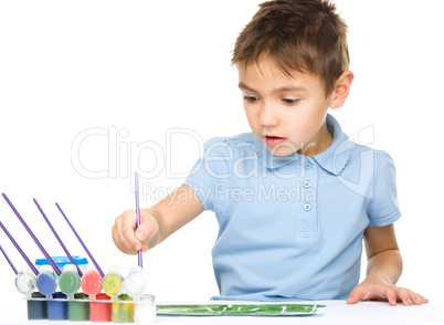 Boy is playing with paints