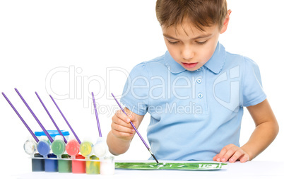 Boy is playing with paints