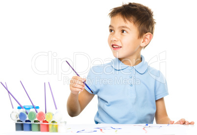 Boy is playing with paints