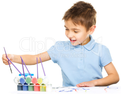 Boy is playing with paints