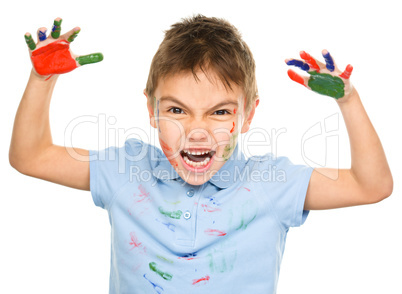 Portrait of a cute boy playing with paints