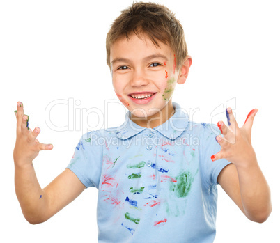 Portrait of a cute boy playing with paints