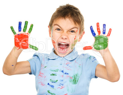 Portrait of a cute boy playing with paints