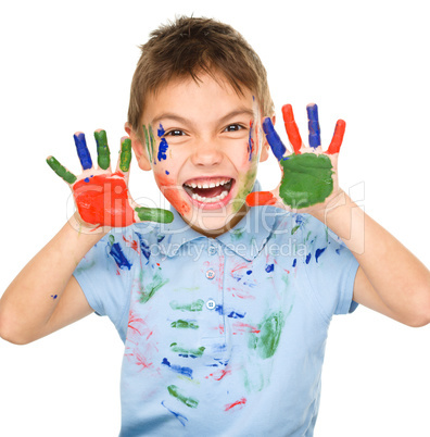 Portrait of a cute boy playing with paints