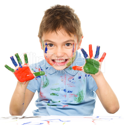 Portrait of a cute boy playing with paints