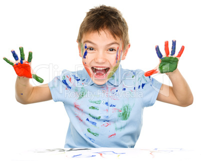 Portrait of a cute boy playing with paints