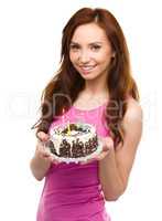 Young woman with anniversary cake