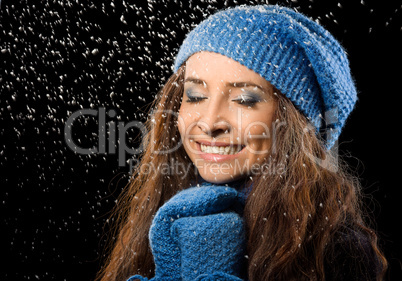 Young happy woman under snowfall