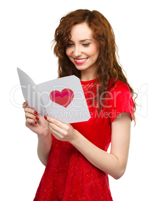 Young woman is reading Valentine card