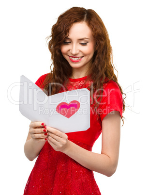 Young woman is reading Valentine card
