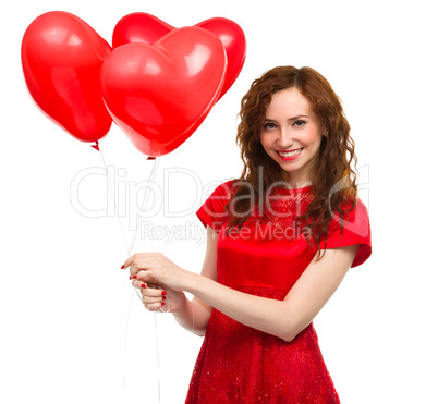 Young woman holding heart-shaped balloons