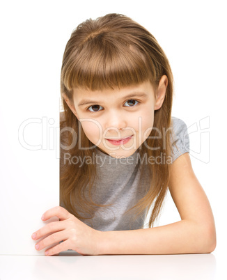 Little girl is looking out from the blank banner