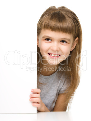 Little girl is looking out from the blank banner