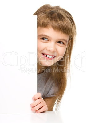 Little girl is looking out from the blank banner