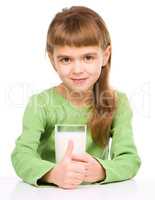 Happy little girl with a glass of milk