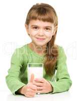 Happy little girl with a glass of milk