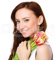 Young woman is holding bouquet of tulips