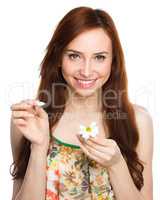 Young woman is tearing up daisy petals