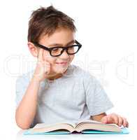 Little boy is reading a book