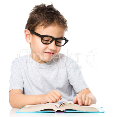 Little boy is reading a book