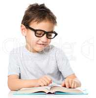 Little boy is reading a book