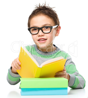 Little boy is reading a book