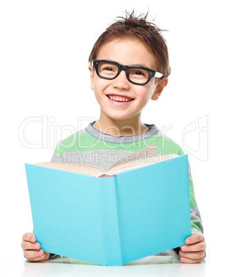 Little boy is reading a book