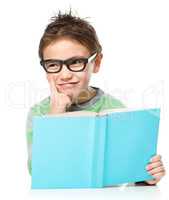 Young boy is daydreaming while reading book