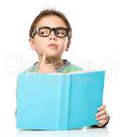 Young boy is daydreaming while reading book