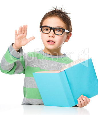 Little boy is reading a book