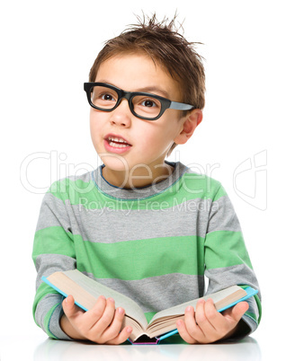 Little boy is reading a book