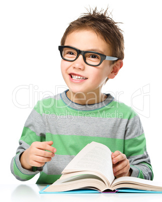 Little boy is reading a book